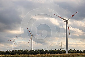 Modern wind turbines in front of a cloudy sky