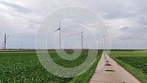 Modern wind turbines on a green landscape with a cloudscape in the background in Meinz Germany