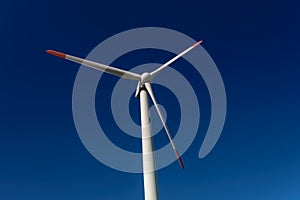 Modern Windmill Turbine on intense blue sky