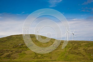 Modern windmills on a green hill