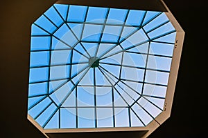 Modern window in the roof of the building, designed for natural light and ventilation. Sky through the glass window at the top of