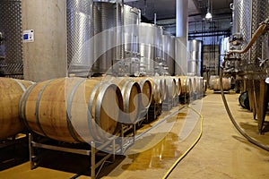 Modern winery with aluminium tanks and wine barrels