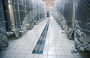Modern winery interior, large shiny fermentation vats in perspective