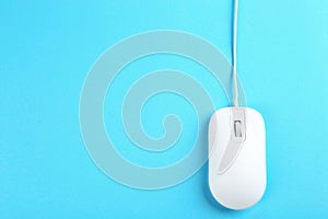 Modern wired mouse on light blue, top view. Space for text