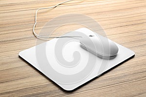 Modern wired optical mouse and pad on table