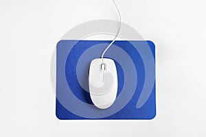 Modern wired optical mouse and pad on white background