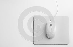 Modern wired optical mouse and pad on background, top view