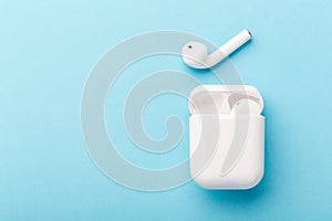 Modern wireless bluetooth headphones with charging case on a blue background