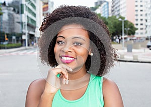 Modern woman from Africa in a green shirt in city