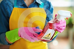 Modern woman with cleaning agent reading instruction