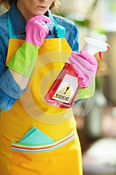 Modern woman with cleaning agent reading instruction