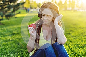 Modern woman with dreadlocks listening to music with her headphones in autumn Sunny Park. Melomania and good mood