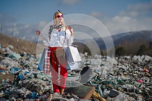 Modern woman on landfill, consumerism versus pollution concept.