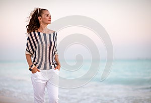 Modern woman on seacoast in evening walking