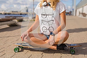 Modern woman sitting on longboard