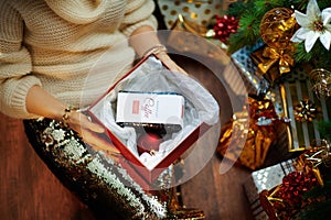 Modern woman unwrapping christmas presents and got coffee