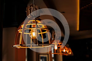 Modern wooden ceiling lamps with vintage bulbs in restaurant interior, office building or home living decoration style