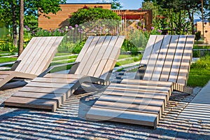 Modern wooden deck chairs or chaise longues for patio or garden