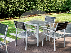 Modern wooden dining table set in the green garden