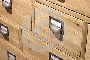 Modern wooden drawers boxes filing cabinet with blank mockup metal file labels tags with copy space