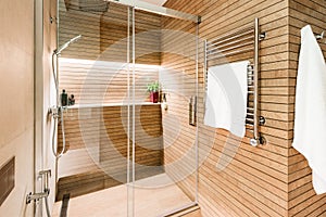 Modern wooden-effect bathroom with glass shower cabin and heated towel rail