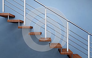 Modern wooden staircase with chromed railing