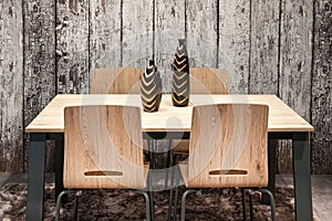 Modern wooden table and chairs with vases