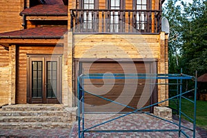 Modern wooden timber eco house villa facade during process of renovation, sanding wall for varnishing against sun burn
