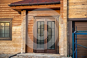 Modern wooden timber eco house villa facade during process of renovation, sanding wall for varnishing against sun burn