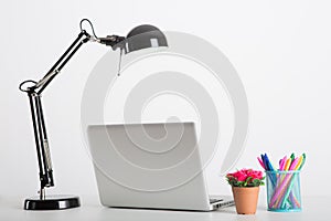 Modern work table with computer laptop and accessories in white background studio.Freelance designer or blogger concepts ideas.