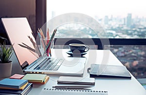 Modern work table with computer laptop and cityscapes view.from window.Business concepts ideas