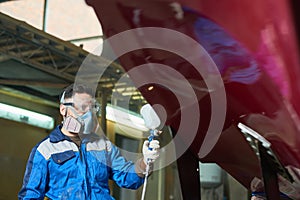 Modern Worker Painting Boat in Workshop