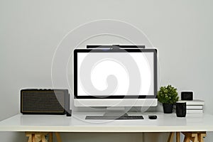 Modern workplace with bank screen of desktop computer on desk. White empty screen for graphic display montage