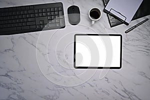 Modern workplace with digital tablet, notepad and coffee cup on marble background.