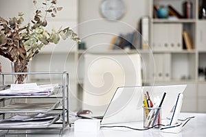 Modern workplace with laptop and telephone, stylish organizers with stationery in light office. Workspace ergonomics