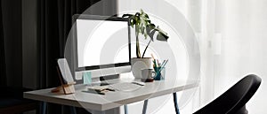 Modern workplace with mock up computer, smart phone and plant on white desk.