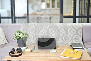 Modern workplace. Still life view of a home office room with digital tablet, notebook, wireless headphones and sofa