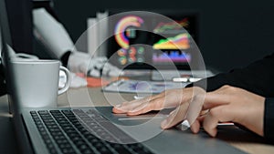 Modern Workplace with Technology and Automation, Focus on Laptop Use and Data Visualization in Background Setting