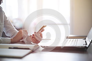 Modern workplace woman using mobile phone in office.