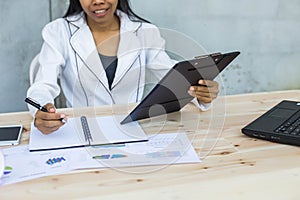 Modern workplace woman using mobile phone sitting at wooden table in office