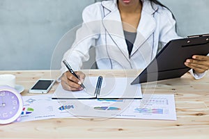 Modern workplace woman using mobile phone sitting at wooden table in office