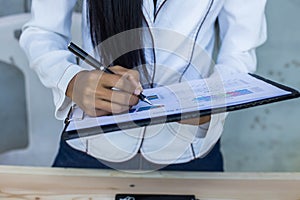 Modern workplace woman using mobile phone sitting at wooden table in office