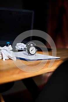 Modern workplace, wooden office desk in hardlight, sunligt with clock, sheet of paper