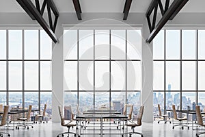 Modern workplaces in a modern bright clean interior of a loft style office. Huge windows with New York panoramic view. Black desks