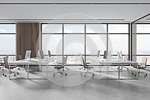 Modern workspace interior with pc monitors and chairs, panoramic window