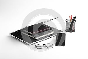 Modern workspace with laptop keyboard, notebook, spectacles on white background