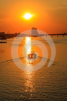 Modern yacht sailing on the Dnieper river at sunset in Dnipro, Ukraine