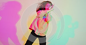 Modern young girl, cool dancing in colorful neon light. Dance school advertising video. Contemporary female dancer