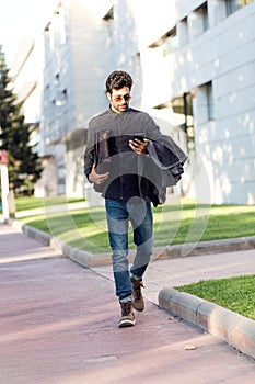 Modern young man using his mobile phone in the street.