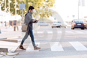 Modern young man using his mobile phone in the street.